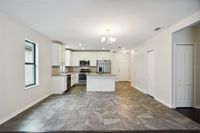 kitchen with pendant lighting, white cabinets, a center island, stainless steel appliances, and sink