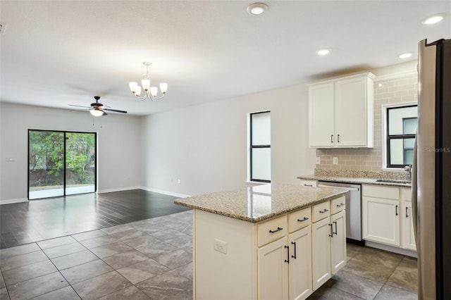 kitchen with white cabinets, decorative backsplash, appliances with stainless steel finishes, and a kitchen island