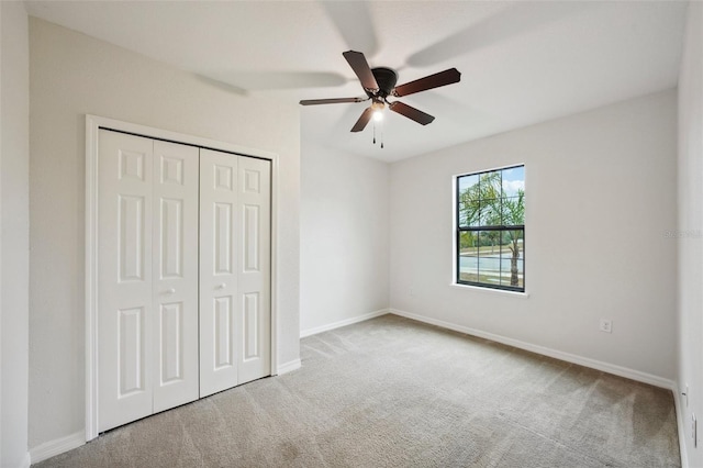 unfurnished bedroom featuring ceiling fan, a closet, and carpet floors