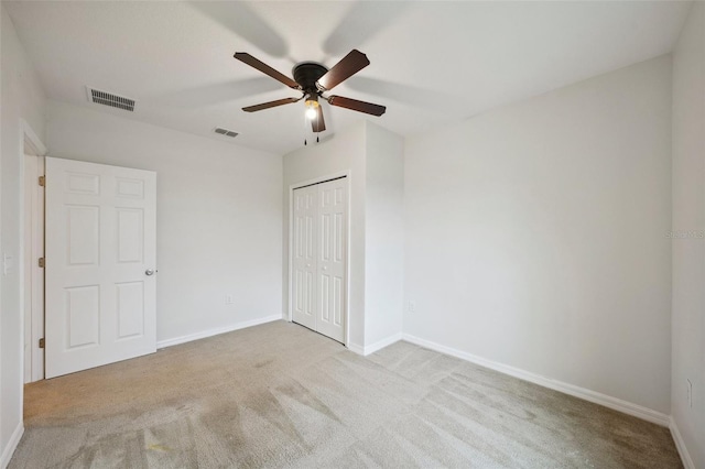 unfurnished bedroom featuring ceiling fan, a closet, and light colored carpet