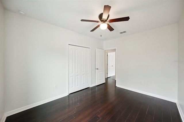 unfurnished bedroom featuring ceiling fan, dark wood-type flooring, and a closet