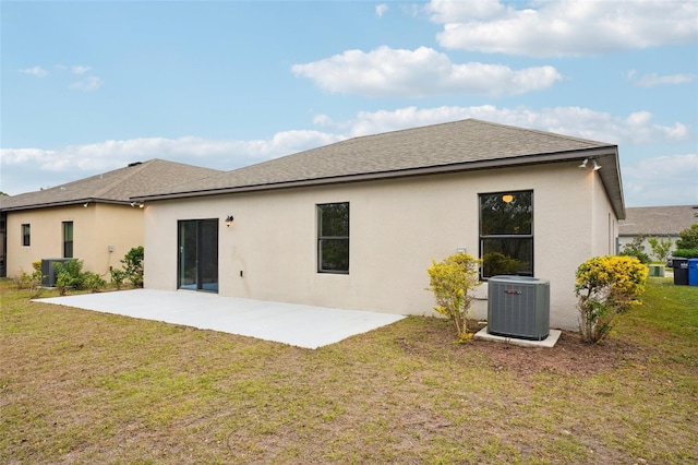 rear view of house with central AC unit, a patio area, and a lawn