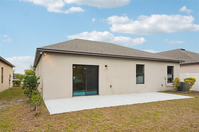 back of property featuring central AC unit, a patio area, and a yard