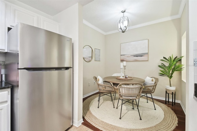 dining space with hardwood / wood-style flooring and crown molding