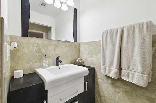 bathroom with vanity and tile walls