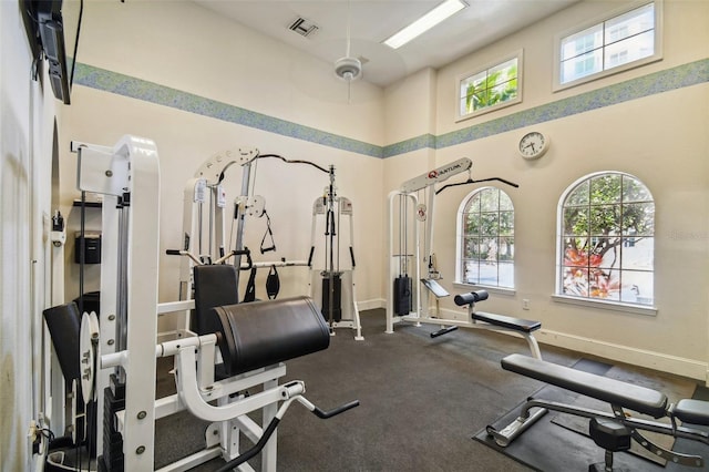 exercise room featuring a towering ceiling