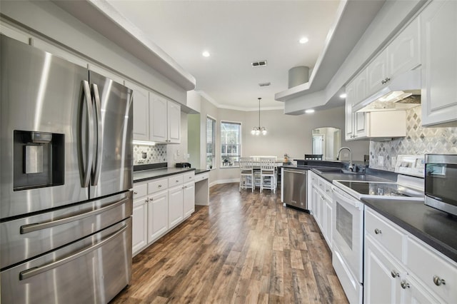 kitchen featuring decorative light fixtures, sink, crown molding, appliances with stainless steel finishes, and white cabinets