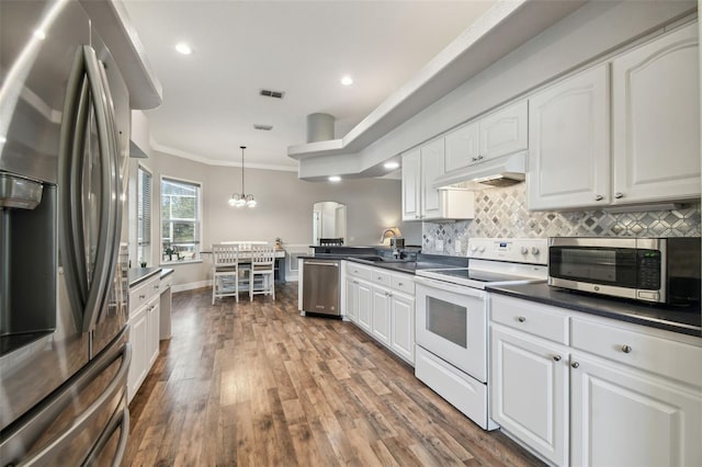 kitchen featuring decorative light fixtures, crown molding, white cabinets, and stainless steel appliances