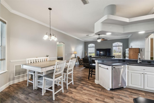 kitchen featuring decorative light fixtures, dark hardwood / wood-style floors, stainless steel dishwasher, sink, and white cabinets