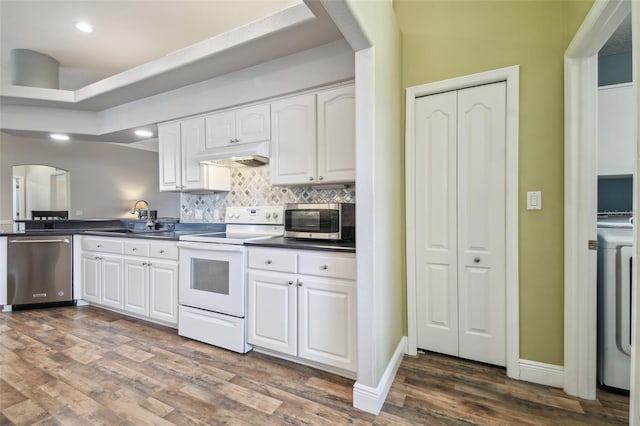 kitchen with dark hardwood / wood-style floors, sink, stainless steel appliances, and white cabinetry