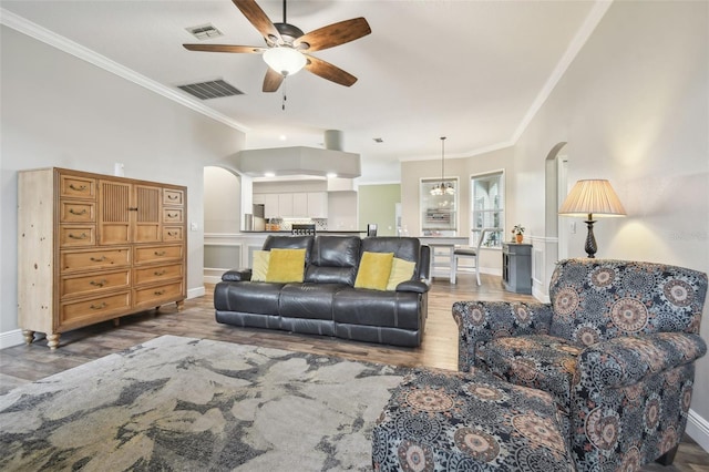 living room with ceiling fan, hardwood / wood-style floors, and ornamental molding