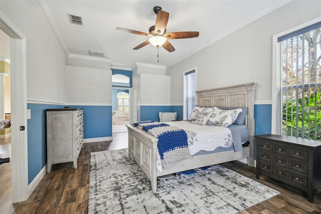 bedroom featuring ceiling fan, ensuite bath, dark hardwood / wood-style flooring, and crown molding