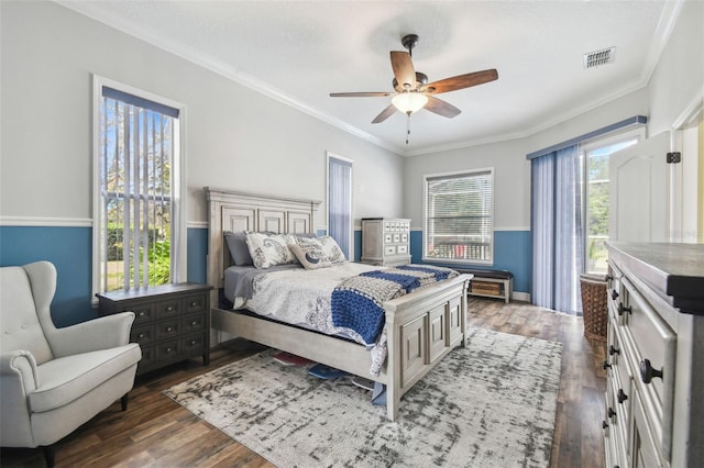 bedroom featuring dark wood-type flooring, ceiling fan, crown molding, and a textured ceiling