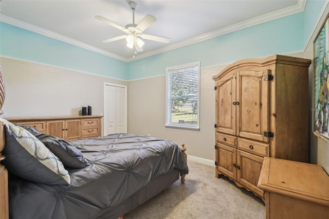 carpeted bedroom featuring ceiling fan, a closet, and crown molding