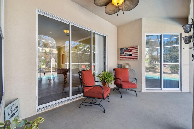 view of patio featuring glass enclosure and ceiling fan