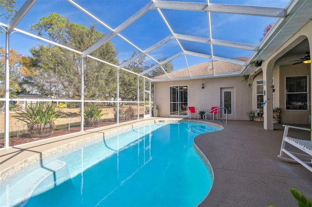 view of swimming pool featuring ceiling fan, glass enclosure, and a patio