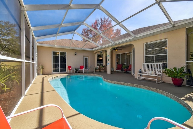 view of swimming pool featuring glass enclosure and a patio area