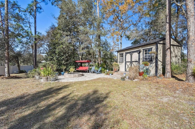 view of yard with an outdoor fire pit and a storage unit