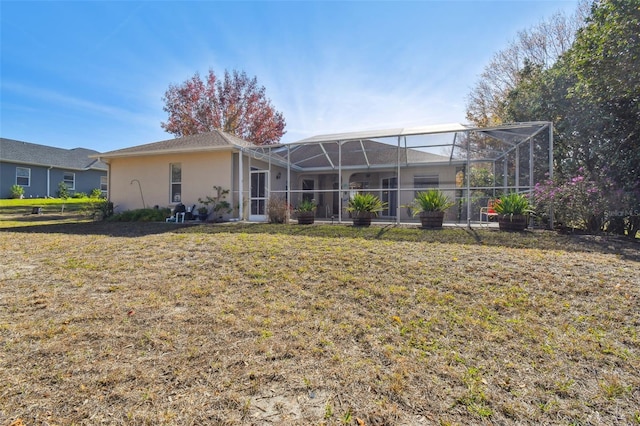 back of property featuring a yard and glass enclosure