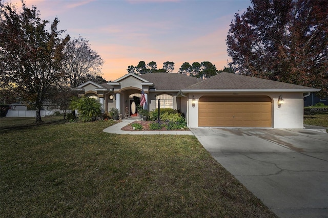 ranch-style house featuring a garage and a yard