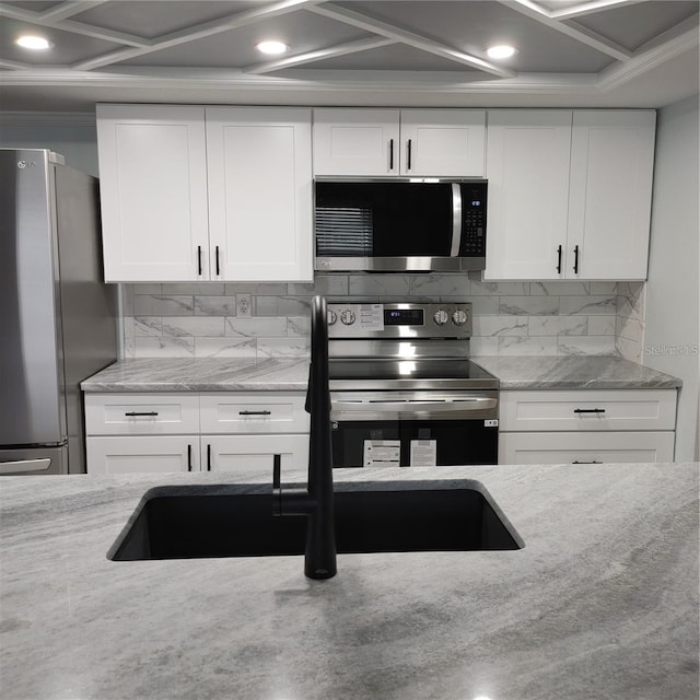 kitchen featuring backsplash, appliances with stainless steel finishes, light stone countertops, and white cabinets