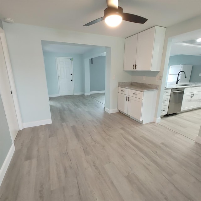 kitchen featuring white cabinetry, sink, light hardwood / wood-style flooring, and stainless steel dishwasher