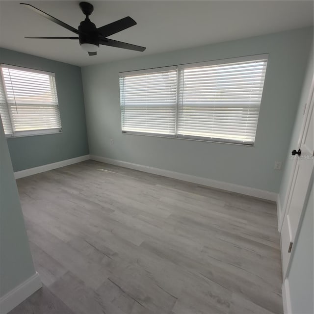 spare room with ceiling fan and light wood-type flooring