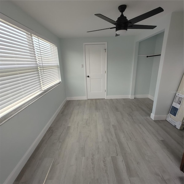 unfurnished bedroom with ceiling fan, a closet, and light wood-type flooring