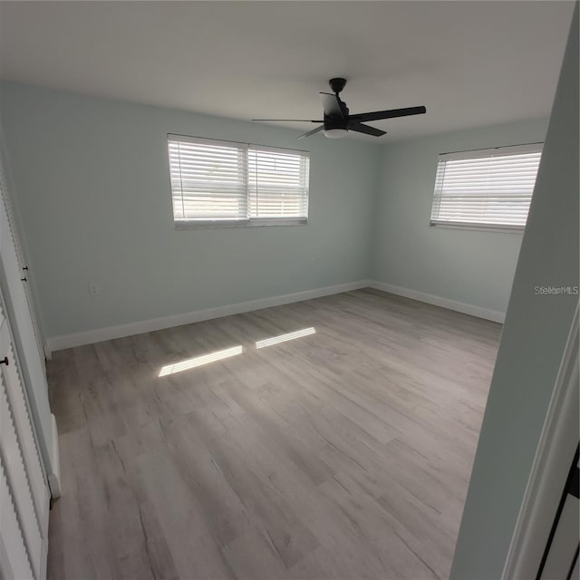 spare room with ceiling fan and light wood-type flooring