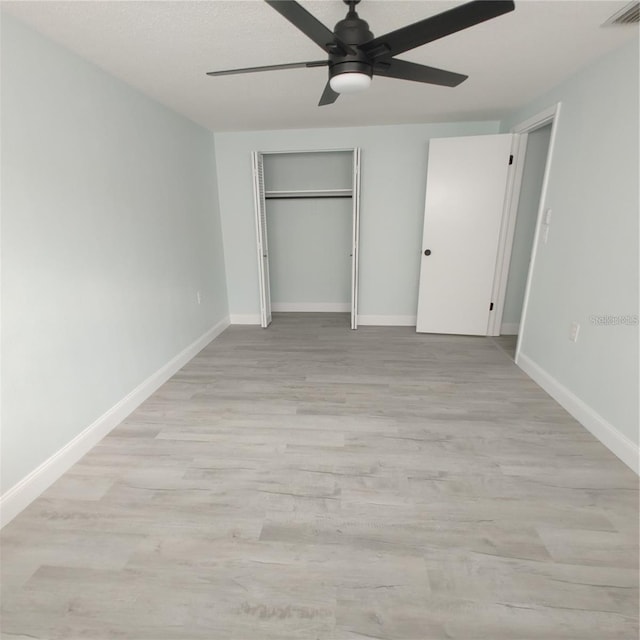 unfurnished bedroom featuring a closet, ceiling fan, and light wood-type flooring