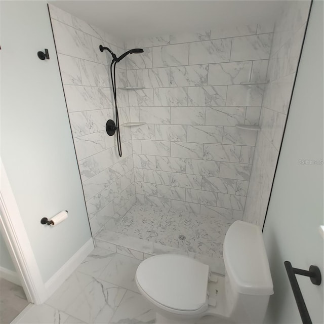 bathroom with tiled shower and toilet