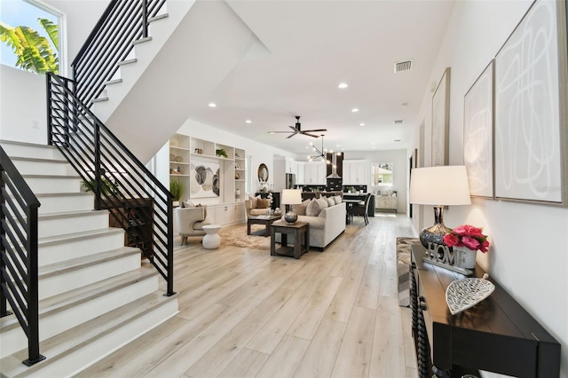 living room featuring ceiling fan and light hardwood / wood-style floors