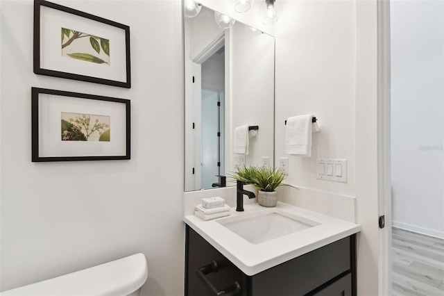 bathroom with vanity, toilet, and wood-type flooring