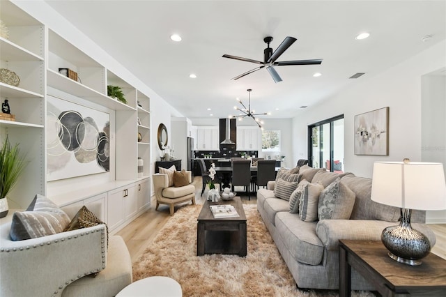 living room featuring a chandelier and light wood-type flooring