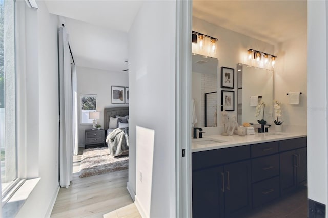 bathroom featuring vanity, hardwood / wood-style flooring, and a shower with door