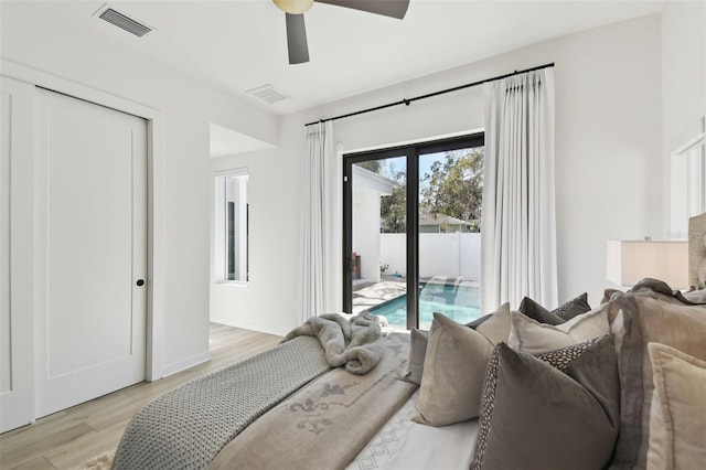 bedroom featuring ceiling fan, access to exterior, light wood-type flooring, and a closet