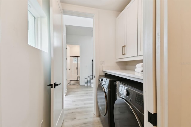 laundry room with cabinets, separate washer and dryer, and light hardwood / wood-style flooring