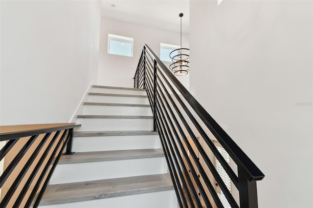 stairway featuring a chandelier