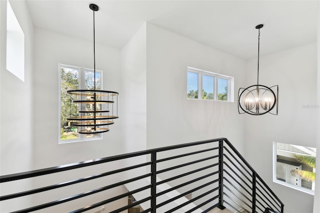 stairway featuring a notable chandelier