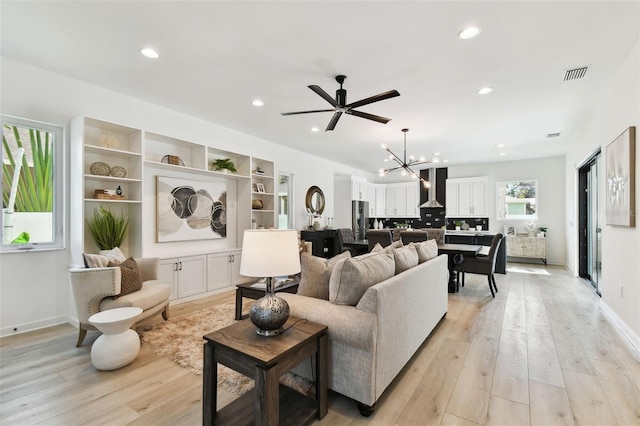 living room with an inviting chandelier and light hardwood / wood-style flooring