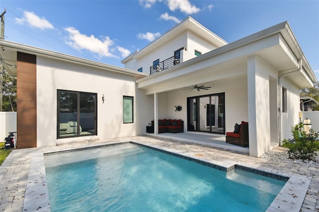 back of house featuring a fenced in pool, a patio area, a balcony, and ceiling fan