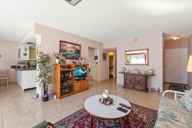 tiled living room featuring a textured ceiling