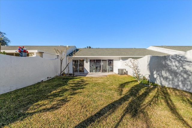 back of house with central AC unit, a yard, and a patio area