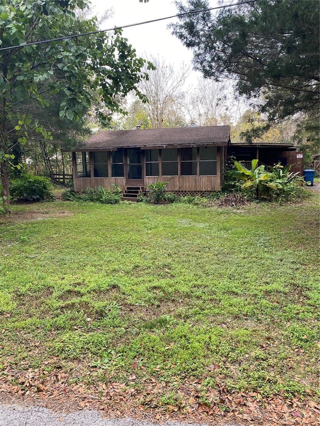 view of front facade featuring a sunroom and a front yard