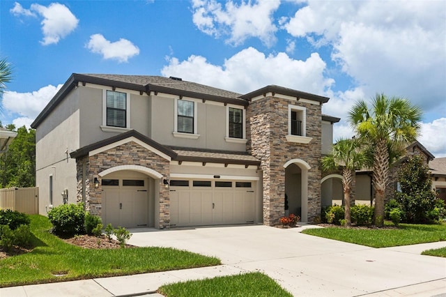 view of front of property featuring driveway, an attached garage, fence, and stucco siding