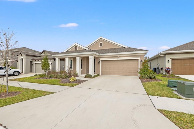 view of front of home featuring a front yard, central AC, and a garage