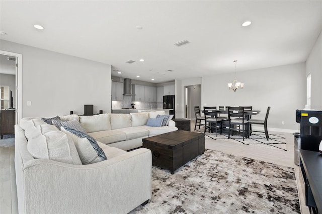 living room featuring light wood-type flooring and an inviting chandelier