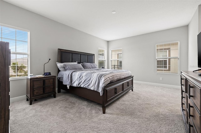 bedroom with light carpet and multiple windows