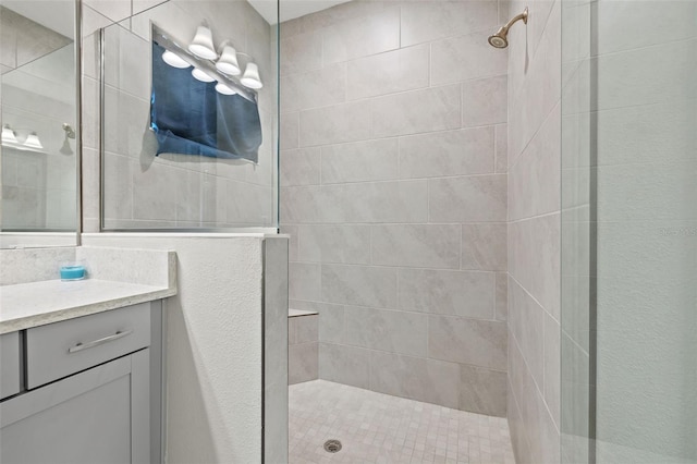 bathroom featuring a tile shower and vanity