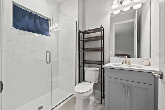 bathroom with vanity, a shower with shower door, and toilet